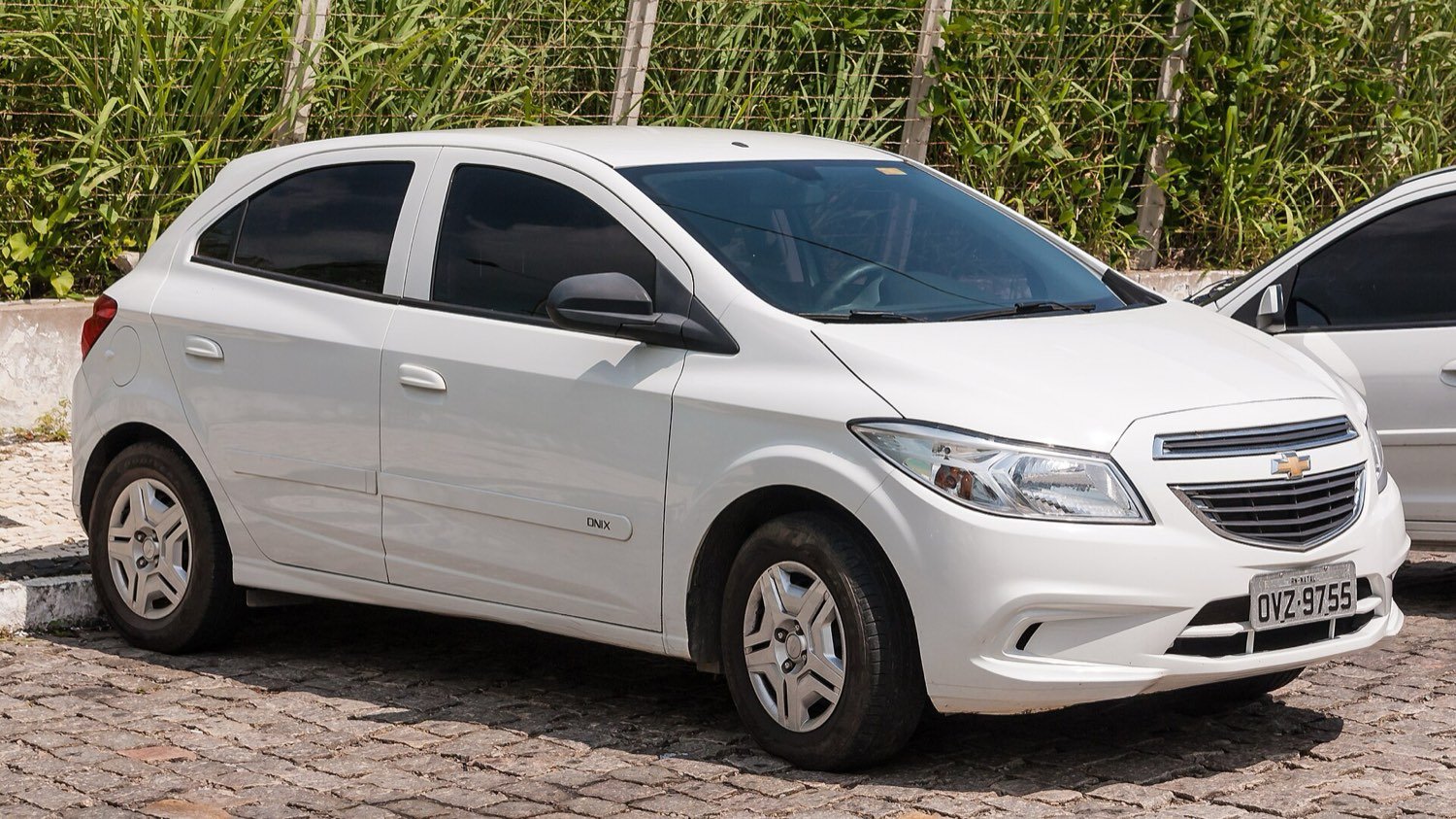 Carro popular branco estacionado em uma rua